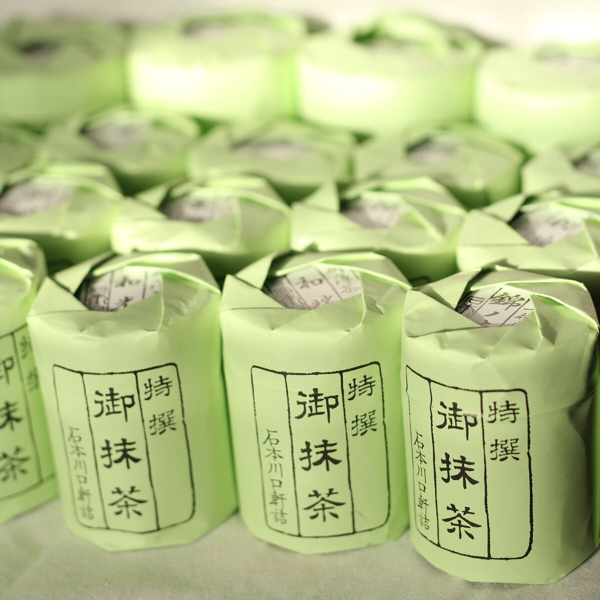 Rows of Ishimoto Kawaguchiken matcha cans wrapped in signature green paper